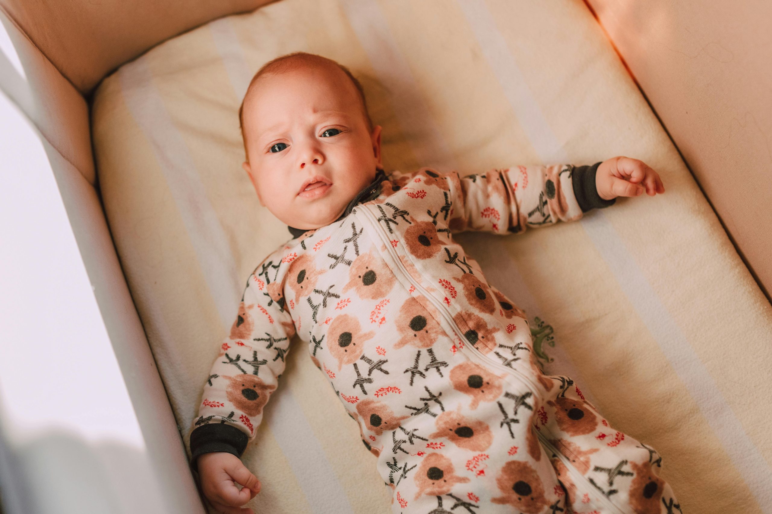 frowning baby lying in a crib