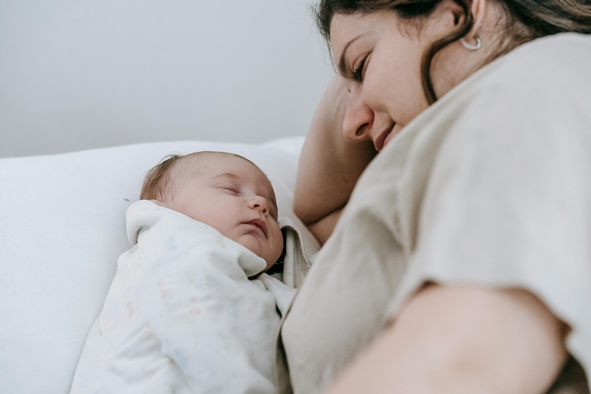 woman watching her baby sleep